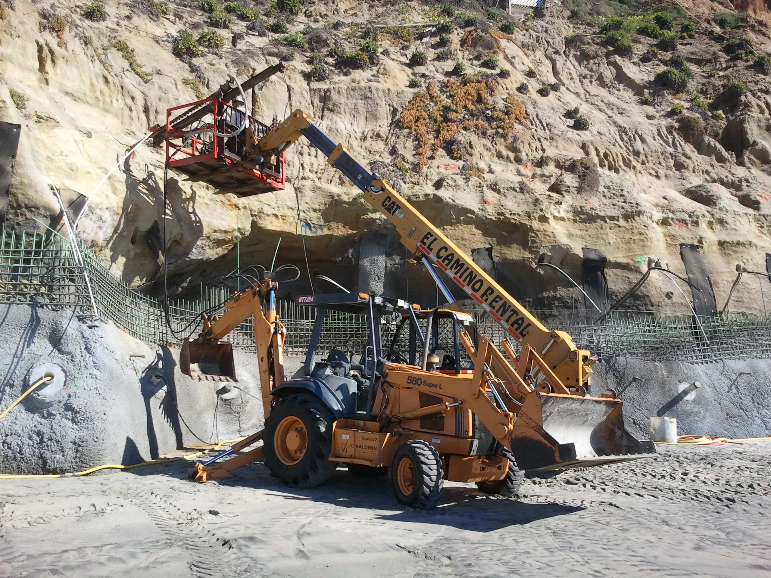 J.C. Baldwin backhoe and crew working on coastal bluff rebar and stabilization