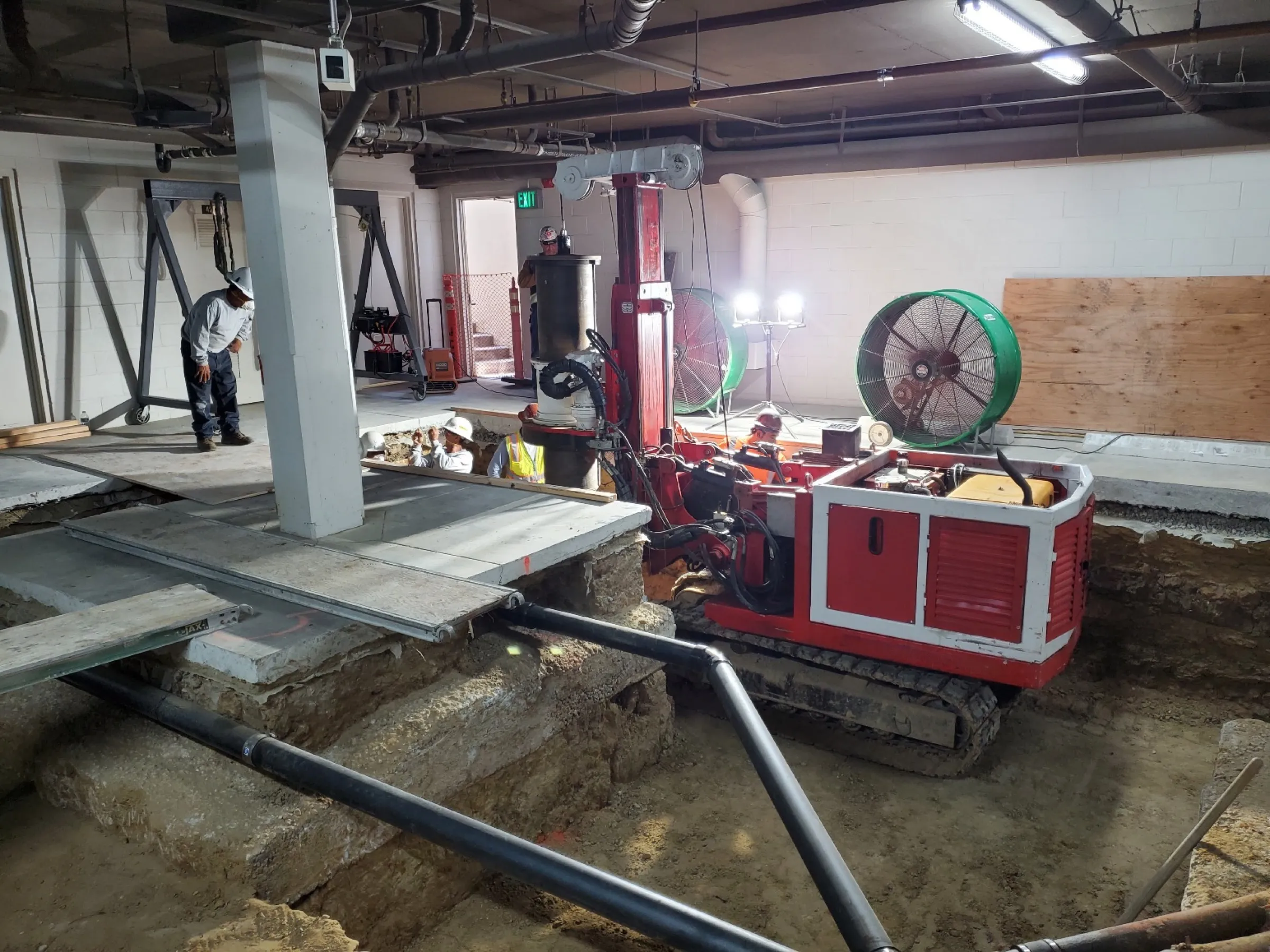 Limited-access drilling rig installing caissons inside the Century Woods parking structure