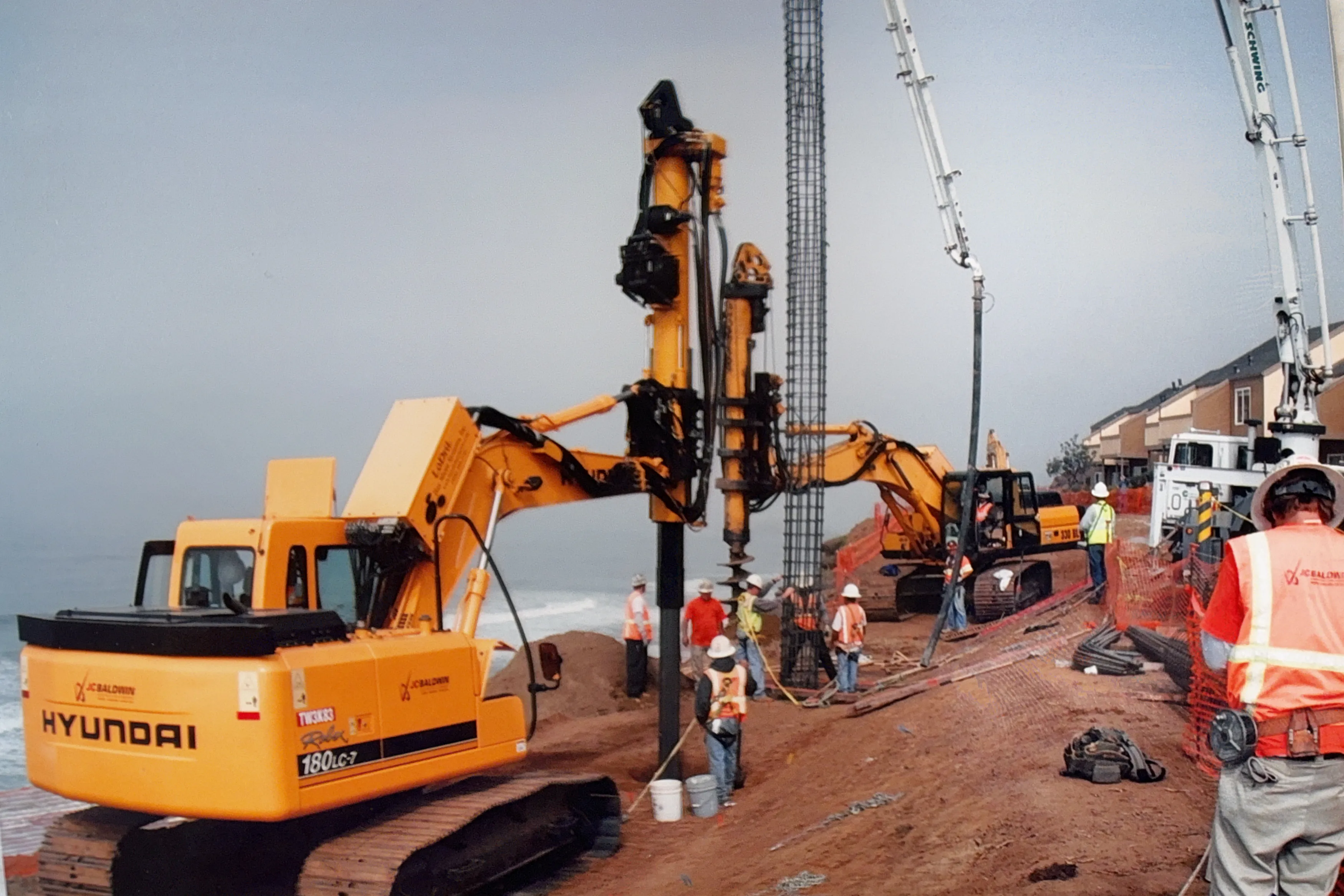 Drilling rig and crew working on a coastal hillside landslide