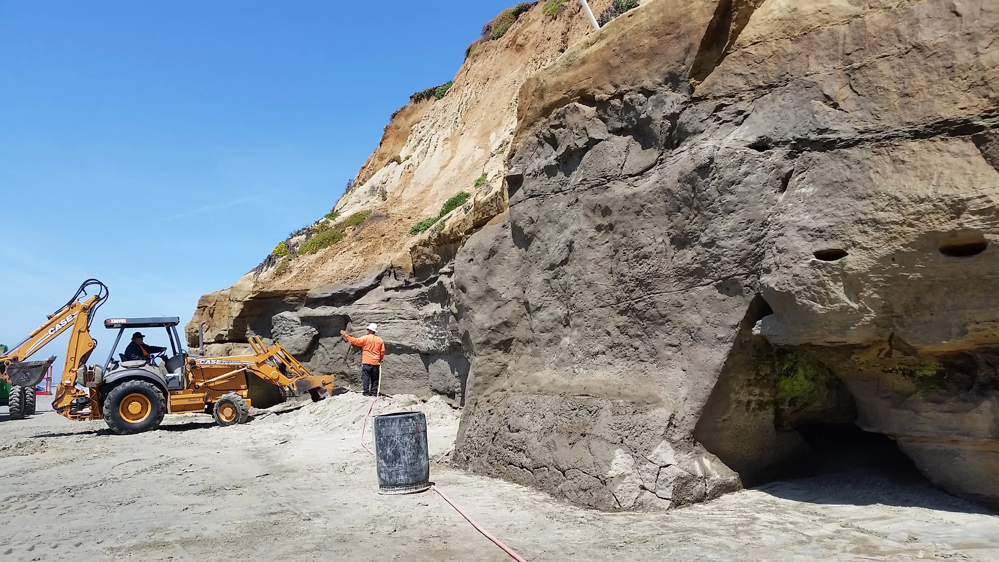 Equipment operating at the base of an eroded coastal bluff