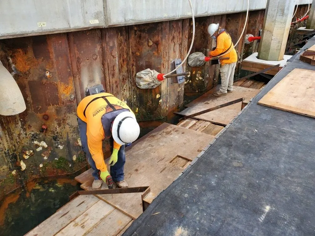Crew working alongside an existing steel sheet pile foundation