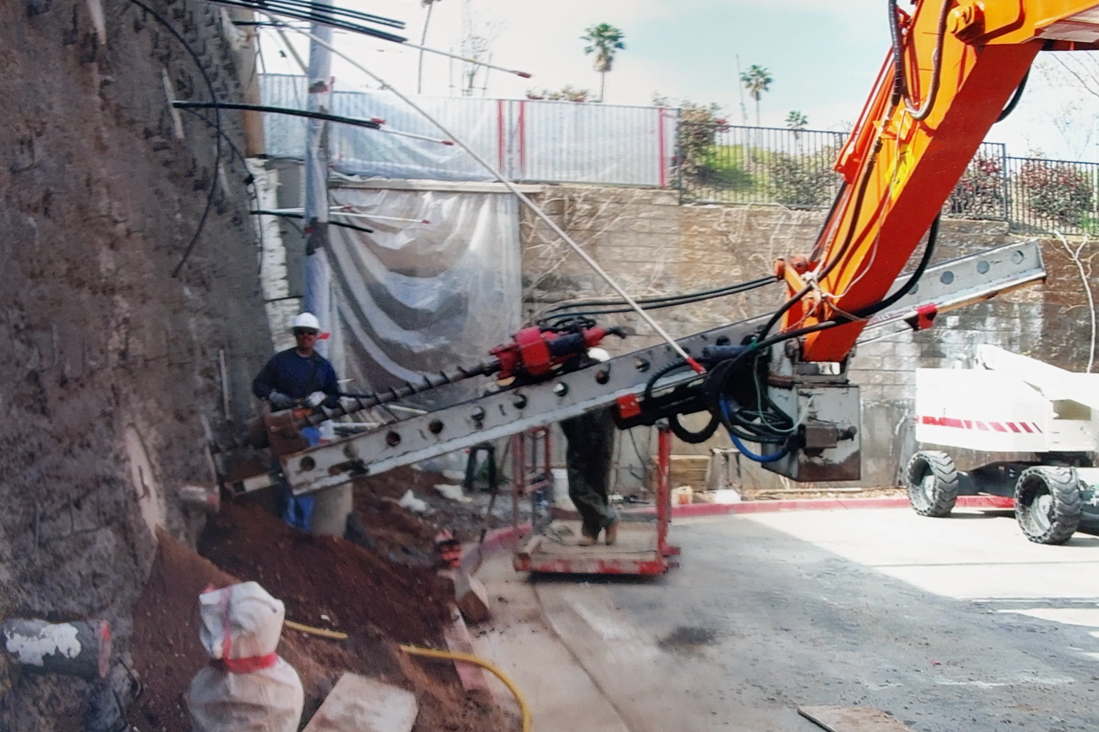Tieback drilling rig boring into the wall face at the Walmart slope stabilization